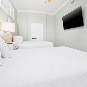 Rest and recharge in this guest bedroom, highlighted by plush queen bedding and a wall-mounted TV for entertainment