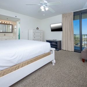 Relax in this master bedroom featuring a king bed, wall-mounted TV, and a scenic view from the large sliding glass doors