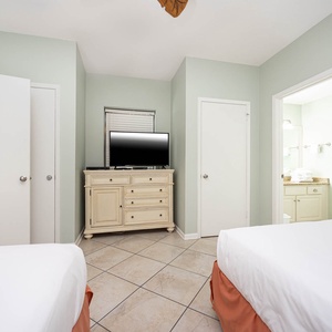 Relax in this guest bedroom with two queen beds, a TV, and easy access to the bathroom