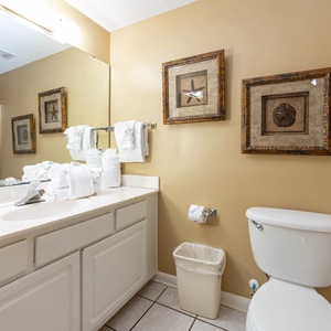 Refresh in the guest bathroom featuring a spacious vanity, fresh towels, and beach decor for a relaxing experience