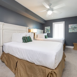 Unwind in the serene guest bedroom featuring two double beds with soft bedding, a TV, and coastal decor