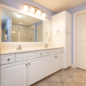 Experience the spacious master bathroom featuring dual sinks, ample storage, and a walk-in shower for your convenience