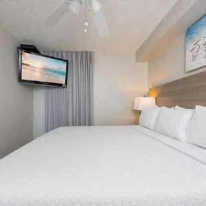 Fluffy pillows invite you to relax in the king suite for a calm movie night after a fun day at the beach