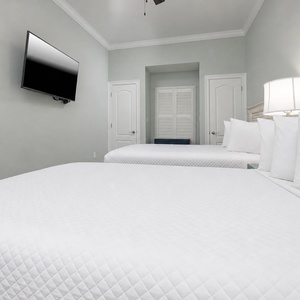 Fluffy bedding and soft colors will surround you in this queen guest suite