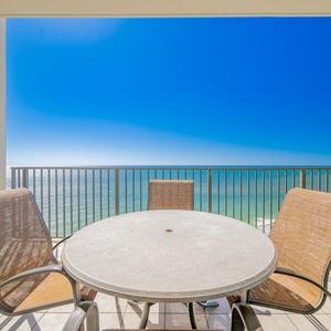 Enjoy a meal from the balcony, featuring a round table and comfortable chairs, perfect for relaxation