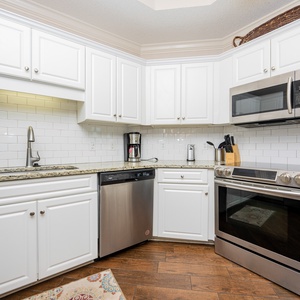 Prepare meals in this kitchen with stylish cabinetry, modern stainless appliances, and tile backsplash
