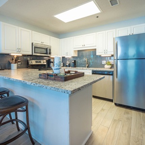 Cook and gather at the spacious kitchen bar with stylish stools and stainless appliances for a delightful meal experience