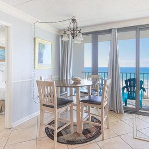 This inviting dining area features a round table and stunning beachfront views, perfect for enjoying meals and relaxation