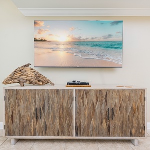 Relax in the living area, featuring a stylish cabinet and a large wall-mounted TV
