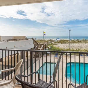 Enjoy a relaxing view from the balcony overlooking the pool and beach, perfect for unwinding after a day of fun
