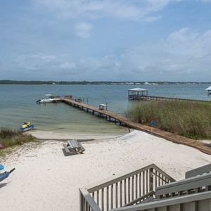 This inviting view showcases vibrant kayaks on the sandy beach, leading to a serene lagoon perfect for water activities