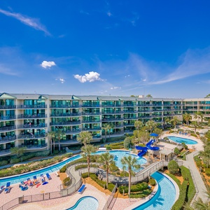 Enjoy the refreshing breeze as you relax on the balcony with views of the pool, lazy river, and fun waterslide