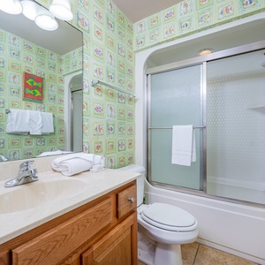 Refresh in this guest bath, where fluffy towels and cheerful decor elevate your beach vibes during your stay