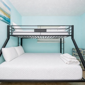 This cozy guest room features a bunk bed and a comfortable double bed, perfect for family or friends