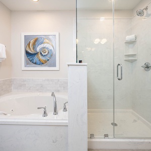 Indulge in relaxation with a spacious jetted tub and a walk-in glass shower in this inviting master bathroom