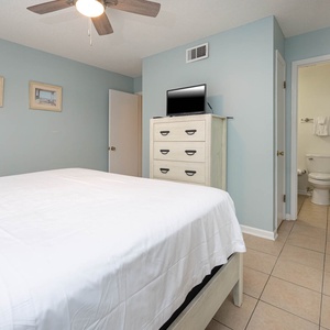 This bedroom features a king bed, light blue walls, and a TV, creating a relaxing atmosphere for guests