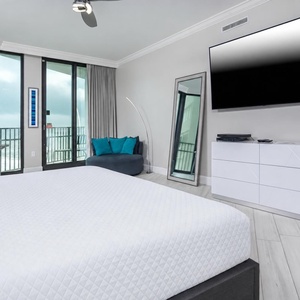Relax in the inviting master bedroom, featuring a king bed, large TV, and a workspace with complimentary WiFi