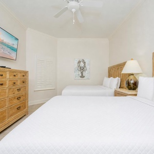 Rest in this cozy guest bedroom, where plush queen beds and a comforting vibe set the stage for restful slumbers