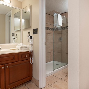 The master bathroom features a stylish vanity with wooden cabinetry, a walk-in shower, and ample natural light
