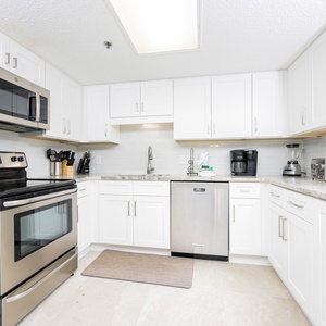 Bright white cabinetry complements the modern kitchen's stainless appliances and sophisticated design