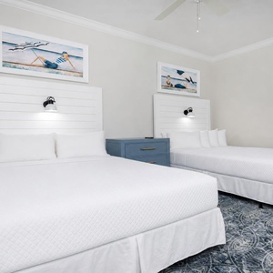 Relaxing queen guest suite with soft bedding, stylish coastal decor, and chic lighting accents