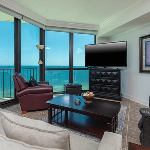 Relax in this inviting living area with large windows offering breathtaking views and comfortable seating options