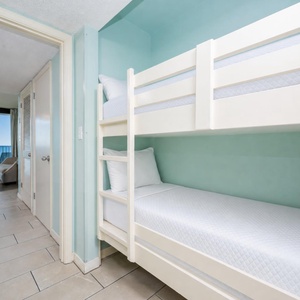 Sleep soundly in these cheerful bunk beds with soft linens in the hallway, perfect for the kids