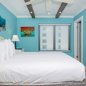 This bedroom features a king-sized bed, vibrant blue walls, and a TV, creating a relaxing retreat for visitors