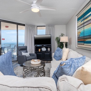 Relax in the inviting living area, featuring plush seating and a view of the beach from the balcony