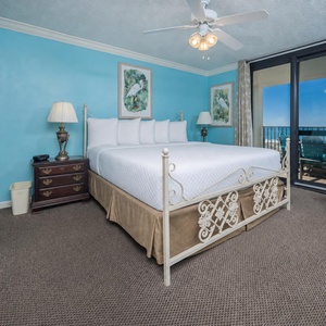 Brightly colored walls complement the master bedroom featuring a king bed, elegant furnishings, and access to a balcony