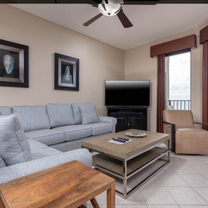Cozy living area features a light gray sofa with queen sleeper, wooden coffee table, and a view of the gulf