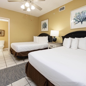 Enjoy restful nights in this inviting guest room featuring two comfortable double beds, warm decor, and cozy vibe