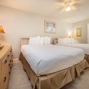 Rest comfortably in this inviting guest bedroom featuring two queen beds, large dresser, and adjoining bathroom