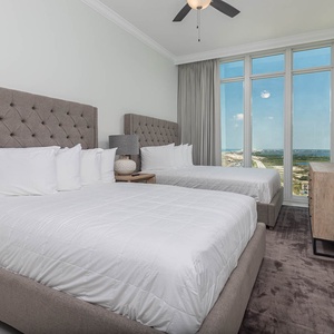 Wake to gulf views through floor-to-ceiling windows from two soft queen beds with upholstered headboards