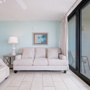Relax in the inviting living area with a view of the beach, featuring a sofa with queen sleeper and TV