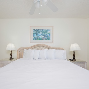 Unwind in the master suite featuring a comfortable king bed, soft linens, and charming coastal artwork