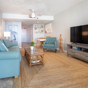 This inviting living area features a large TV, comfortable seating, and a charming coastal decor, perfect for relaxation