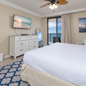 Enjoy restful nights in this inviting master bedroom with a king bed, a TV, and a view that opens to the beachfront balcony