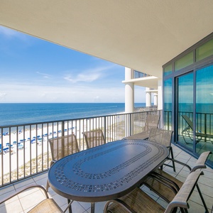 Enjoy spectacular views from the spacious balcony featuring a stylish table and comfortable seating overlooking the beach