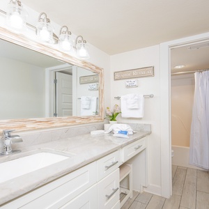 Master bathroom featuring a spacious marble countertop, stylish fixtures, and a tub/shower combo for a refreshing retreat