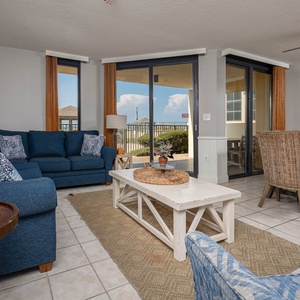 Living area features a sectional sofa with queen sleeper, coffee table, and dining space with chairs, all with natural light