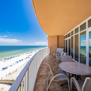 Relax on the spacious balcony with comfortable seating, offering stunning views of the beach and vibrant blue waters