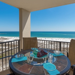 Patio set features turquoise accents, offering a scenic view of the beach and vibrant turquoise waters