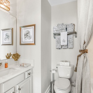 This bathroom features elegant decor with coral accents, a stylish vanity, and soft towels for a refreshing experience