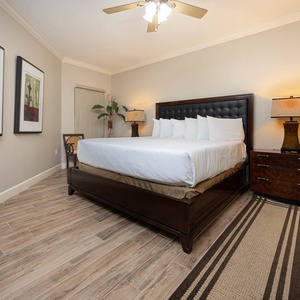 Unwind in this spacious master bedroom featuring a king bed, stylish decor, and warm lighting for a restful retreat
