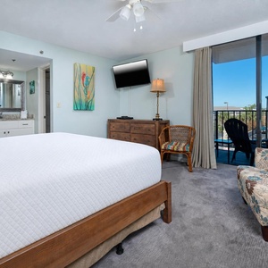 The master features a comfortable king bed, a flat-screen TV, and a lovely view from the balcony