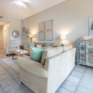 Inviting living area features two cozy sofas and two sleepers, a queen and a full, coffee table, and charming coastal artwork