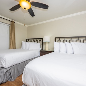 Bright guest bedroom featuring two double beds with stylish headboards and elegant curtains, perfect for restful nights