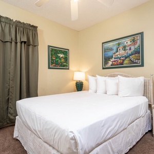 Retreat to this cozy guest bedroom featuring a comfortable queen bed, decorative artwork, and soft lighting for relaxation