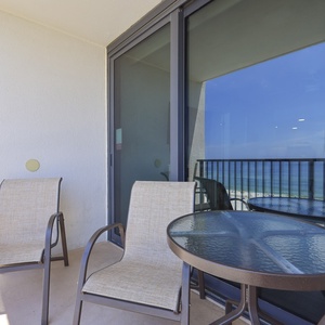 Enjoy a relaxing moment on the balcony with two chairs and a table, featuring a stunning beachfront view